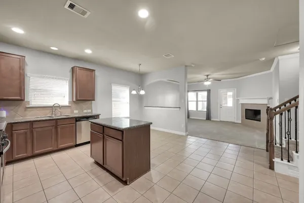 a kitchen with stainless steel appliances granite countertop a stove top oven a sink dishwasher and a refrigerator