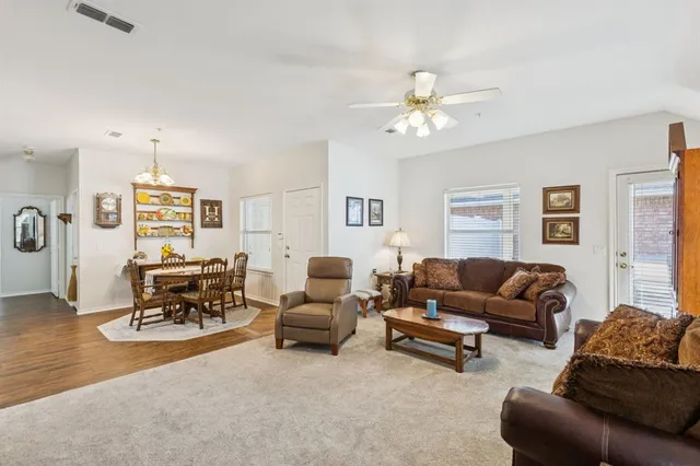a living room with furniture a chandelier and a flat screen tv