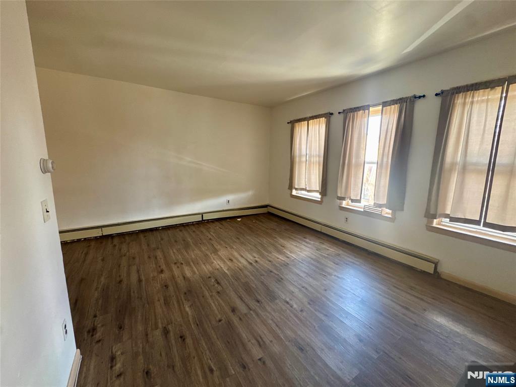 210 Main Street, Unit 2 Ridgefield Park, NJ 07660 - Photo 2 of 4 an empty room with wooden floor and windows