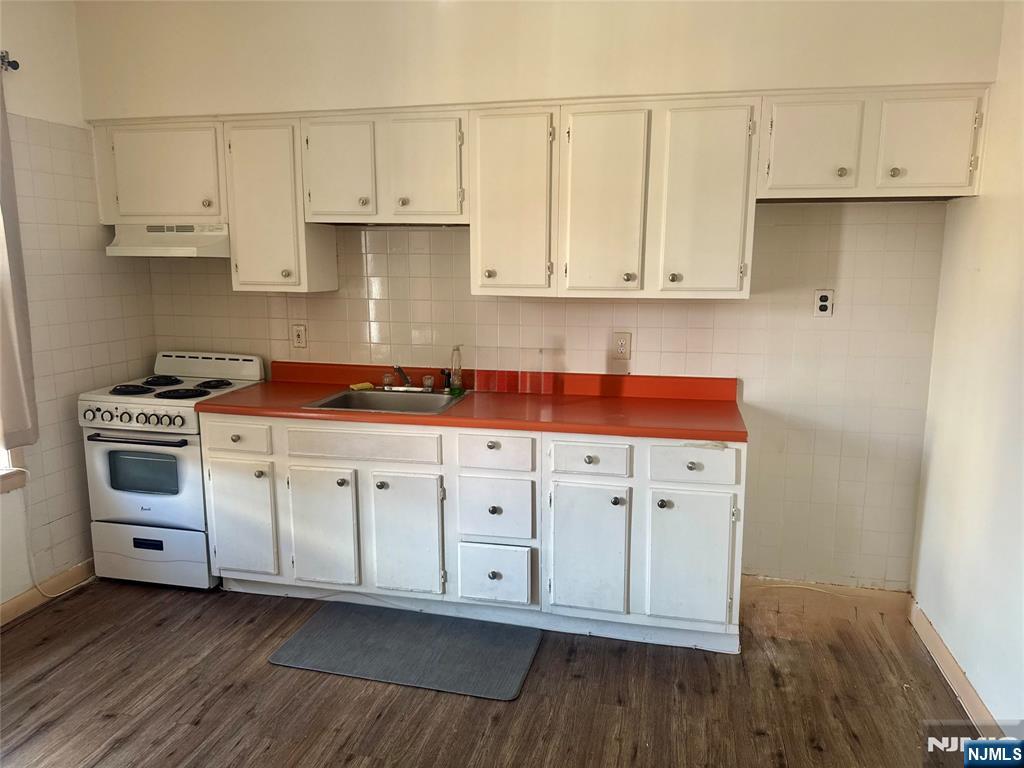 210 Main Street, Unit 2 Ridgefield Park, NJ 07660 - Photo 3 of 4 a kitchen with granite countertop white cabinets and white appliances