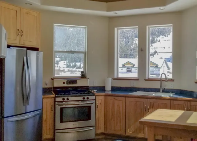 a kitchen with stainless steel appliances granite countertop a sink stove and refrigerator