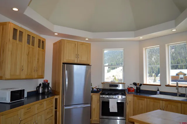 a kitchen with a refrigerator a sink and a stove top oven