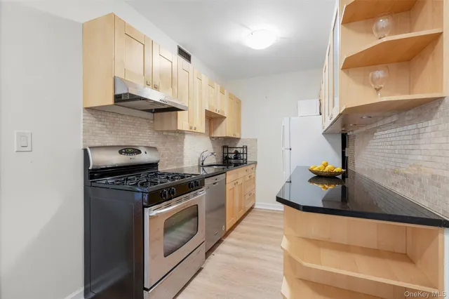 a kitchen with stainless steel appliances granite countertop a stove and a refrigerator