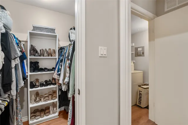 a view of walk in closet with clothes and shoes