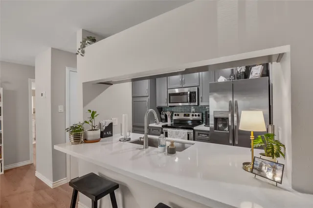 a kitchen with sink refrigerator and microwave