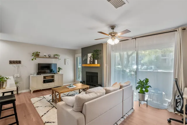 a living room with furniture a fireplace and a floor to ceiling window