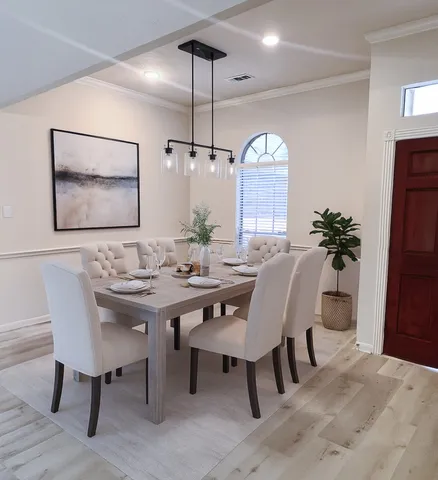 a view of a a dining room with furniture window and wooden floor
