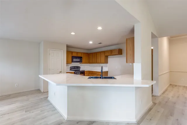 a large kitchen with kitchen island a sink a stove and a refrigerator
