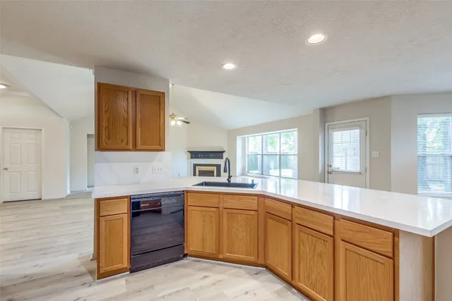 a large kitchen with stainless steel appliances granite countertop a sink and dishwasher a stove with wooden floors