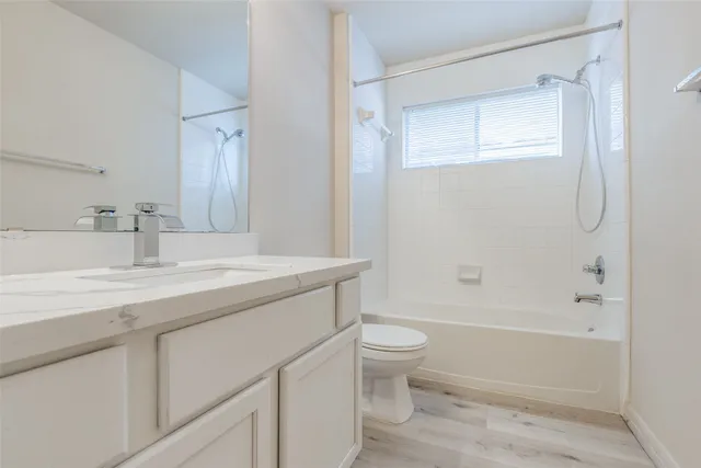 a bathroom with a granite countertop sink a toilet and shower