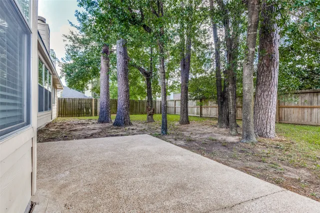 a view of a house with backyard and trees