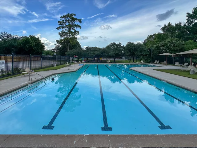 a view of a tennis ground with large trees