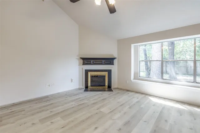 wooden floor fireplace and windows in an empty room