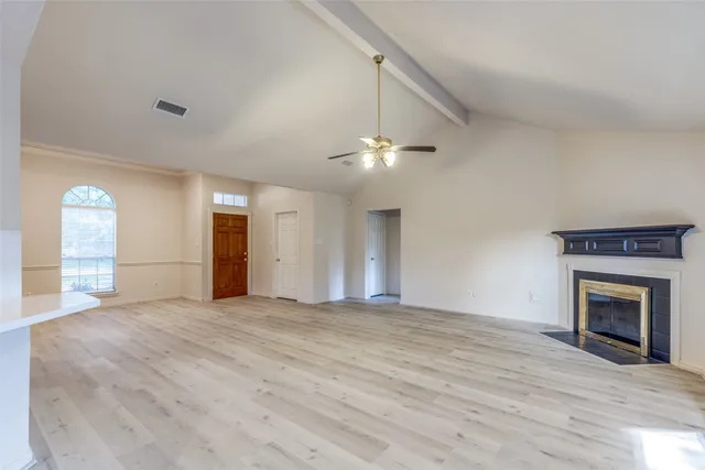 a view of an empty room with window and fireplace