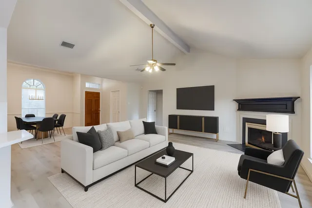 a living room with furniture a flat screen tv and a fireplace