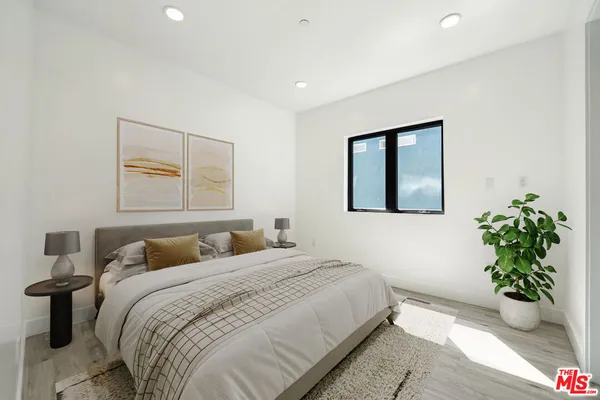 a bedroom with a potted plant and a potted plant