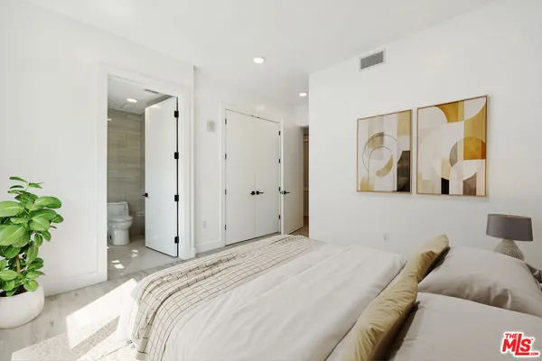 a bedroom with a large bed and a painting on the wall