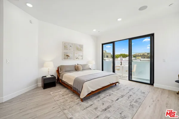 a spacious bedroom with a large bed and a large window