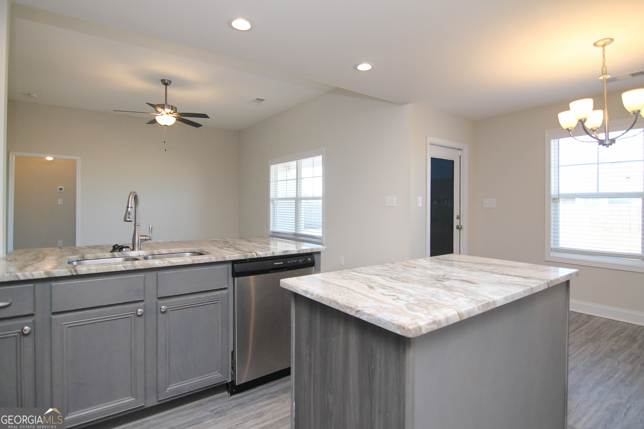 138 Sadie Heights Boulevard Perry, GA 31069 - Photo 12 of 31 a kitchen with granite countertop kitchen island a sink appliances and a center island