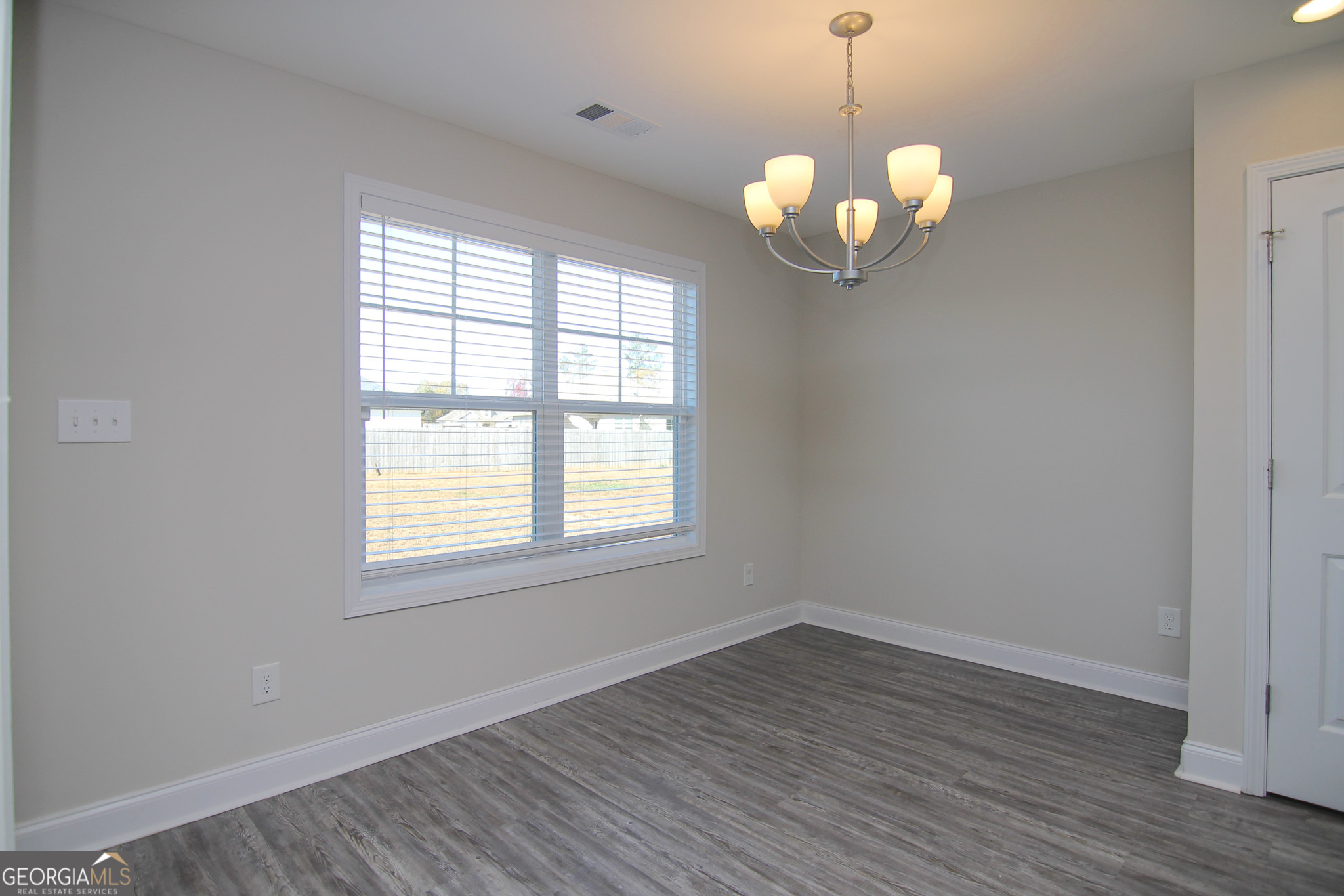 138 Sadie Heights Boulevard Perry, GA 31069 - Photo 13 of 31 an empty room with wooden floor and windows