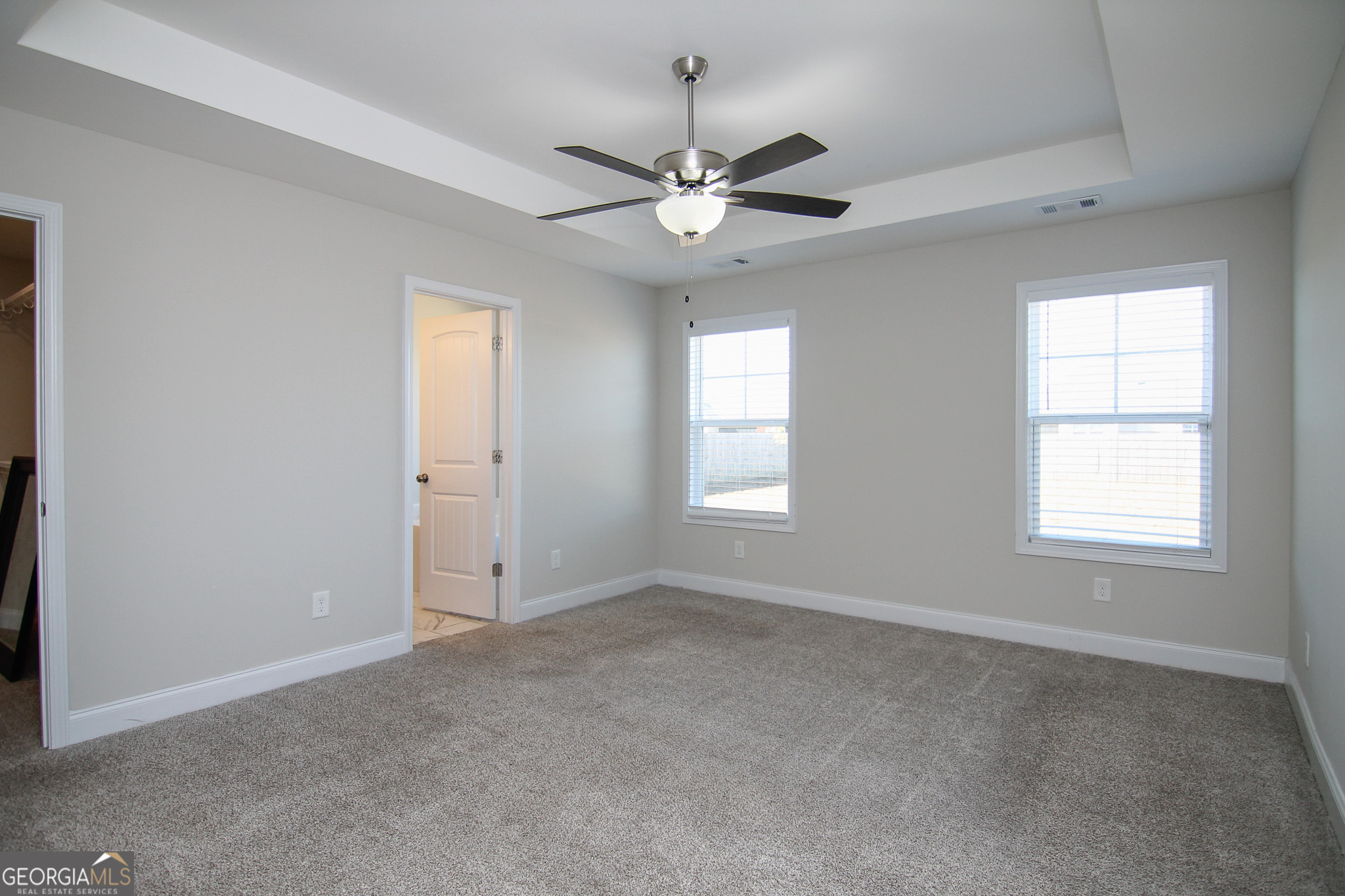 138 Sadie Heights Boulevard Perry, GA 31069 - Photo 14 of 31 an empty room with chandelier fan and windows