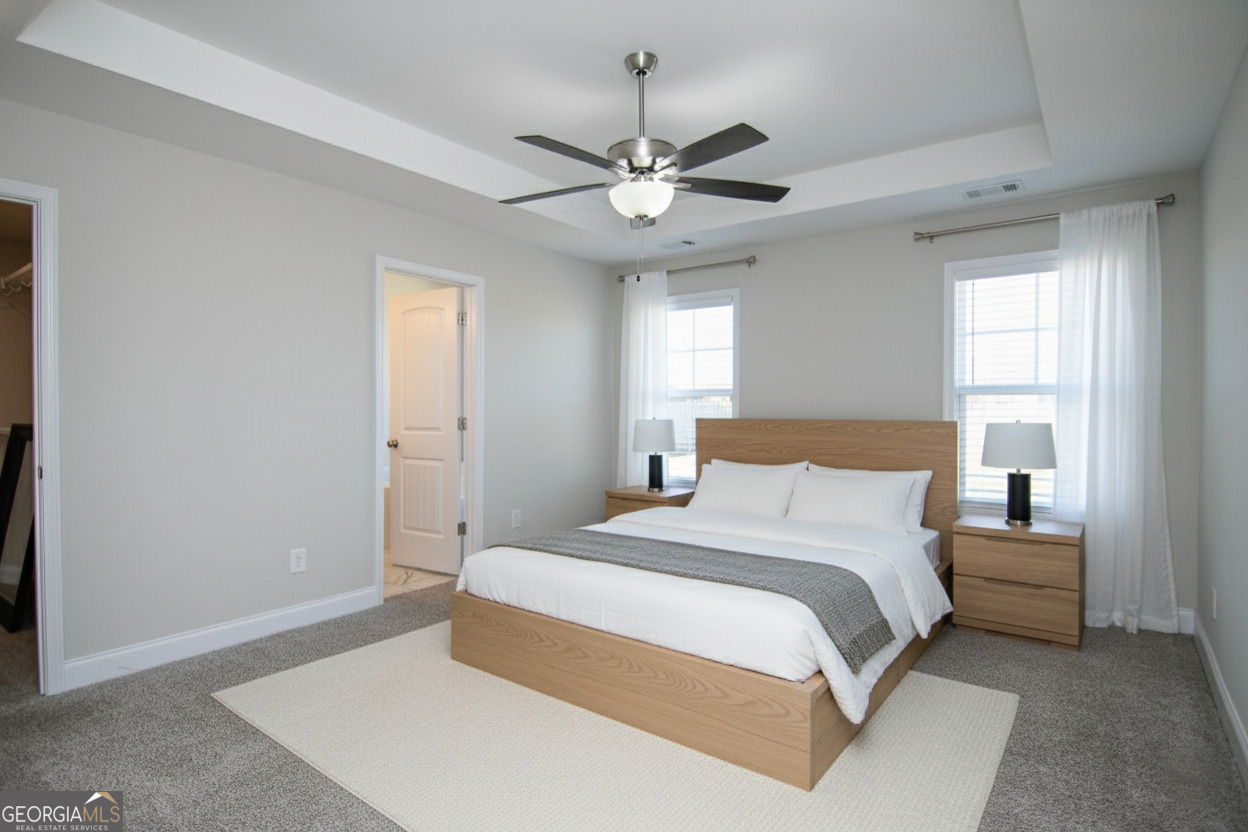 138 Sadie Heights Boulevard Perry, GA 31069 - Photo 16 of 31 a bedroom with a large bed and a chandelier