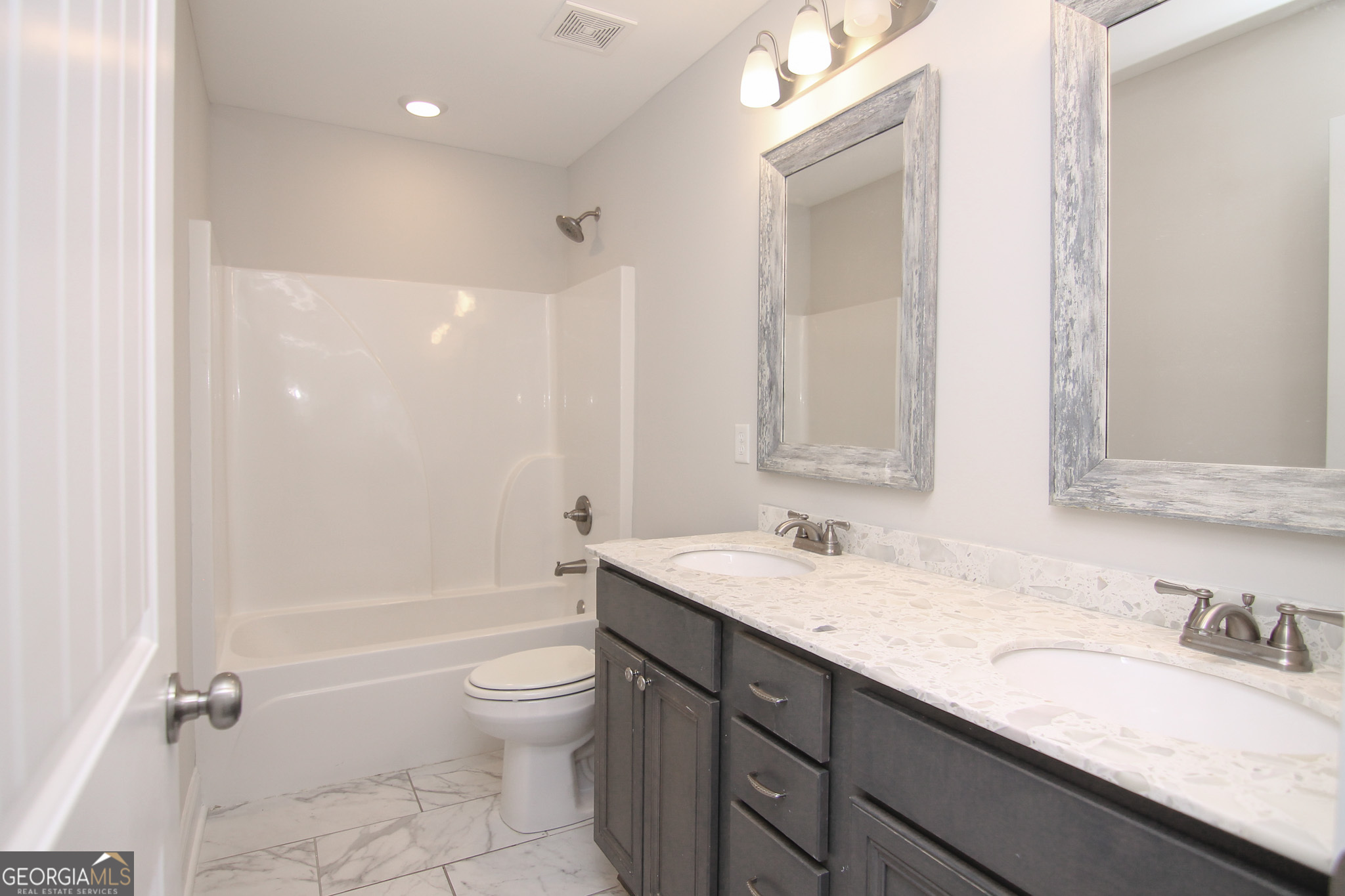 138 Sadie Heights Boulevard Perry, GA 31069 - Photo 27 of 31 a bathroom with a granite countertop sink a toilet and a large mirror