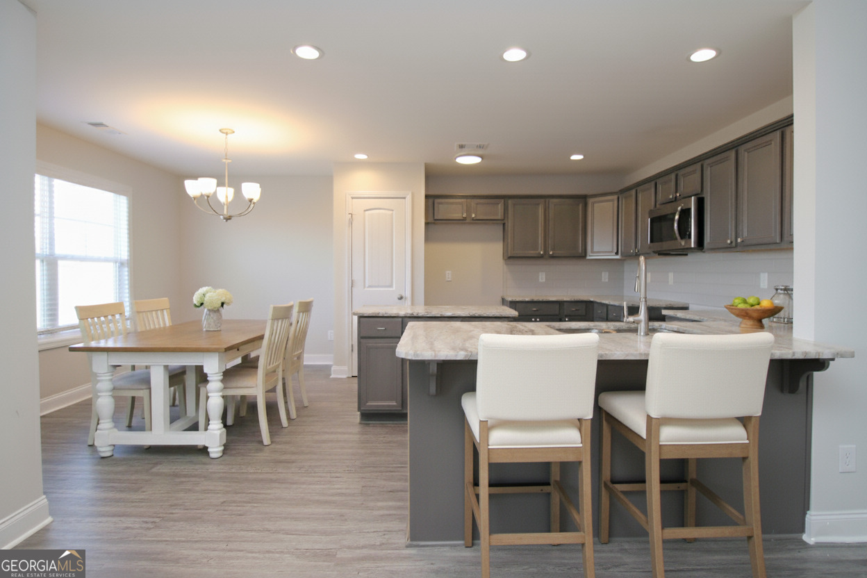 138 Sadie Heights Boulevard Perry, GA 31069 - Photo 8 of 31 a kitchen with a dining table chairs and wooden floor