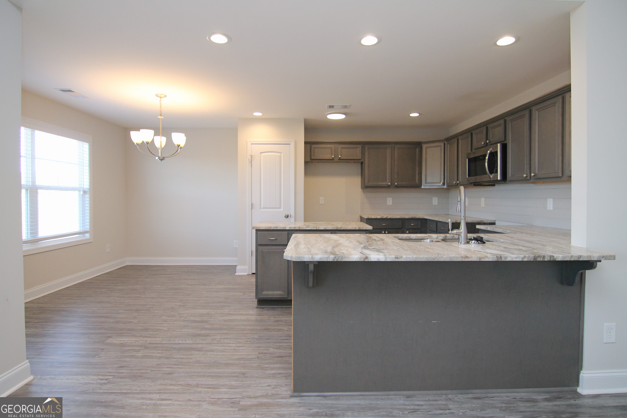 138 Sadie Heights Boulevard Perry, GA 31069 - Photo 9 of 31 a large kitchen with kitchen island a sink stainless steel appliances and cabinets
