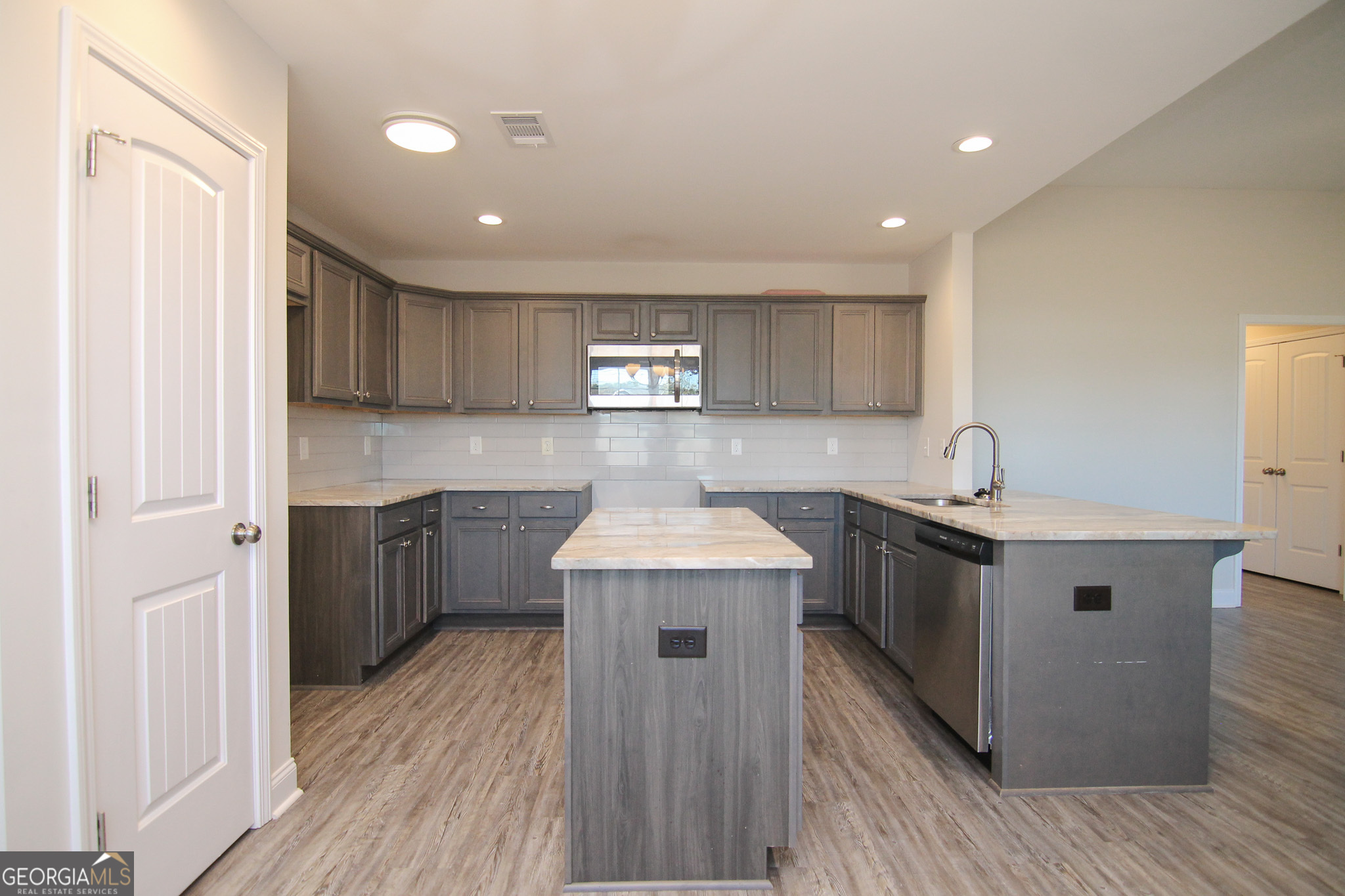 138 Sadie Heights Boulevard Perry, GA 31069 - Photo 10 of 31 a kitchen with a stove sink and cabinets