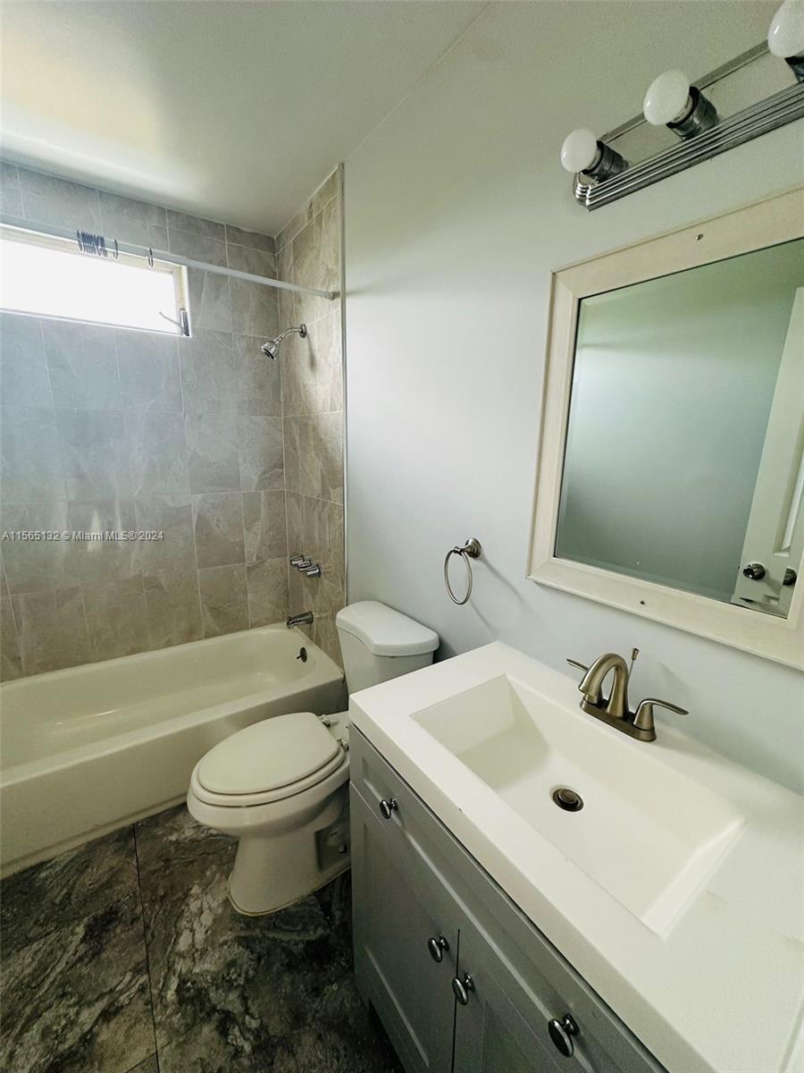 a bathroom with a sink mirror toilet and bathtub