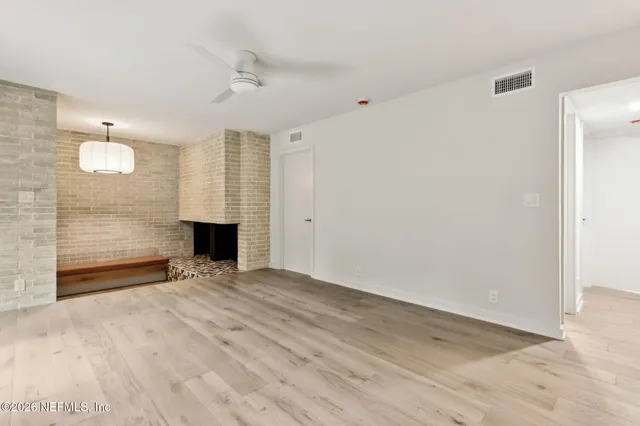 a view of an empty room with a fireplace and a window