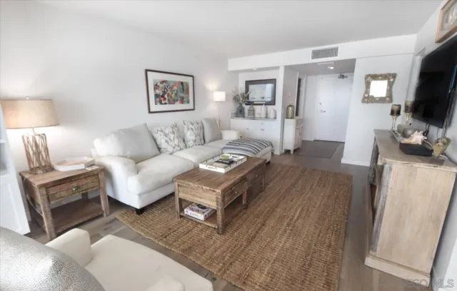 a living room with furniture a flat screen tv and a lamp