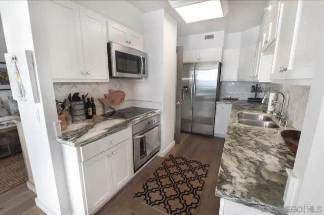 a kitchen with stainless steel appliances granite countertop a refrigerator stove and sink