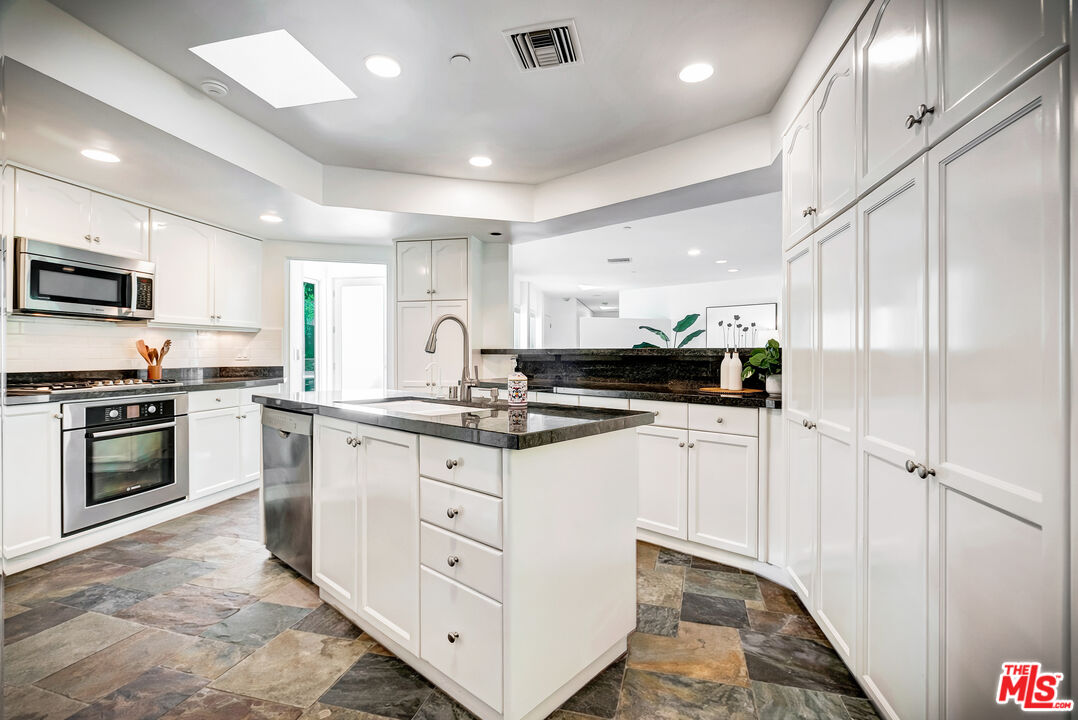 16561 Adlon Road Encino, CA 91436 - Photo 18 of 75 a kitchen with stainless steel appliances granite countertop a stove a sink and a refrigerator