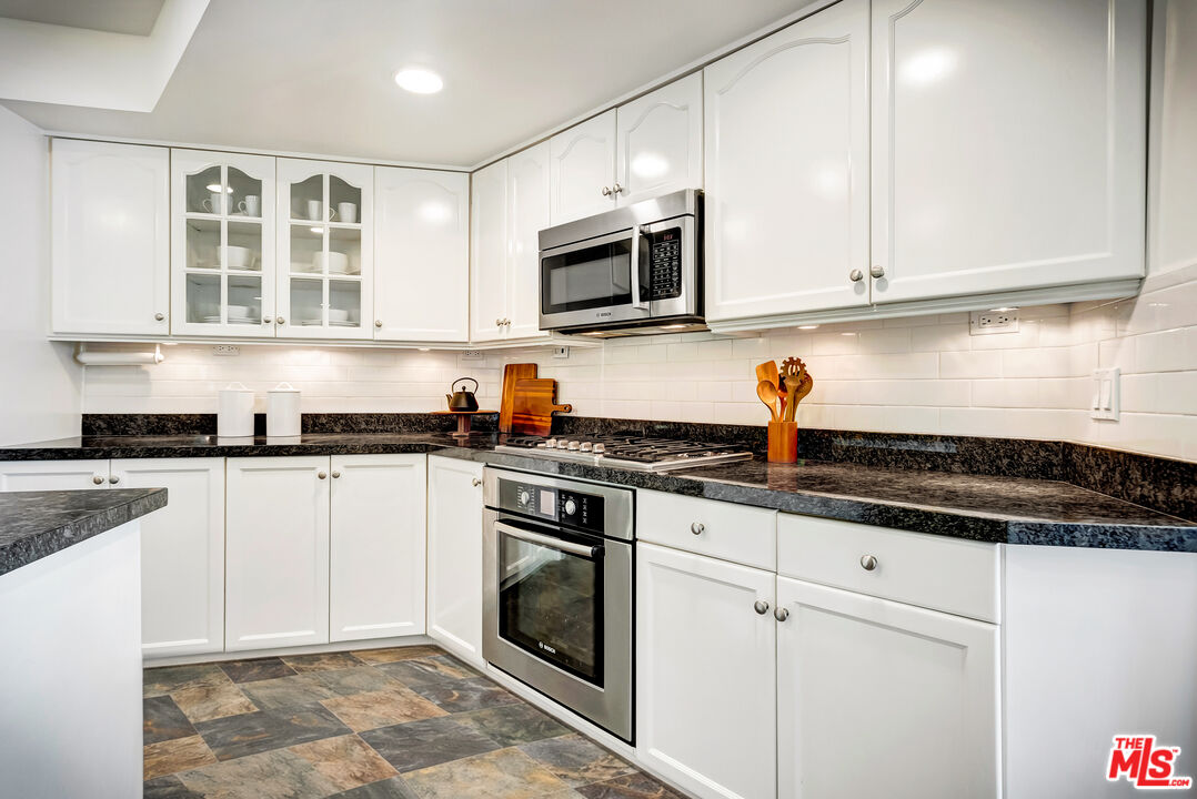 16561 Adlon Road Encino, CA 91436 - Photo 19 of 75 a kitchen with stainless steel appliances granite countertop white cabinets granite counter tops and a hard wood floors