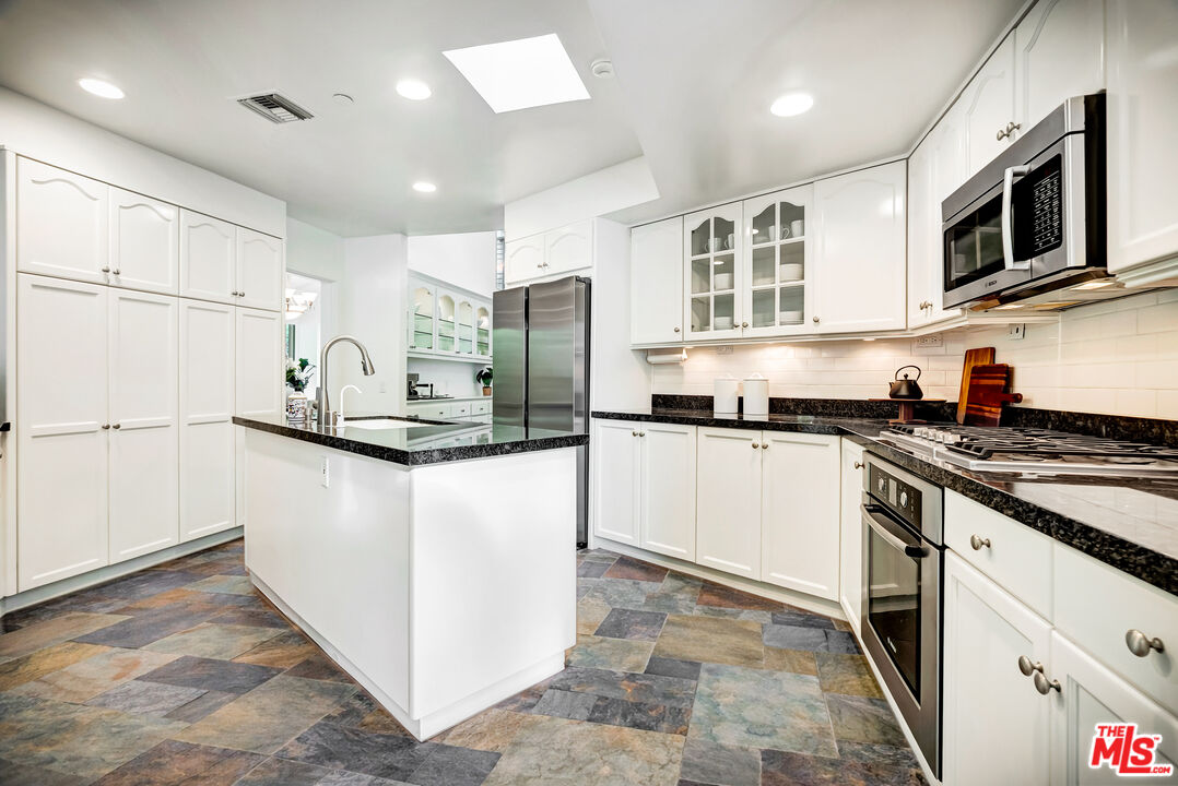 16561 Adlon Road Encino, CA 91436 - Photo 20 of 75 a kitchen with stainless steel appliances granite countertop a refrigerator a stove a sink and a microwave