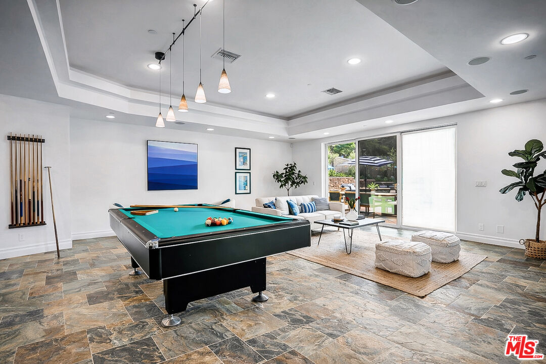 16561 Adlon Road Encino, CA 91436 - Photo 36 of 75 a living room with furniture a table and a flat screen tv