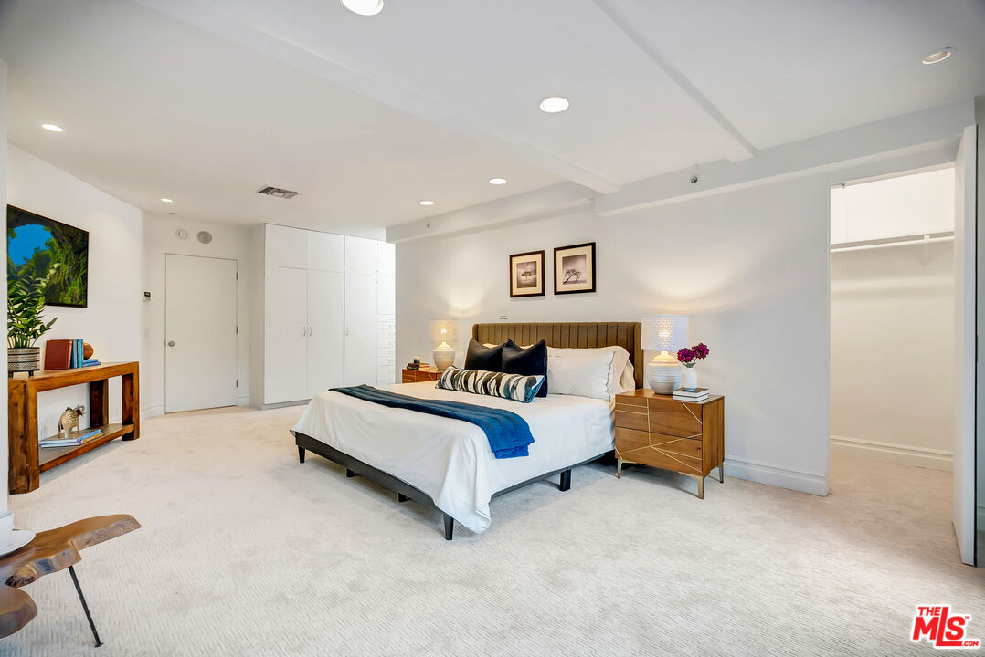 16561 Adlon Road Encino, CA 91436 - Photo 54 of 75 a spacious bedroom with a bed and a flat screen tv