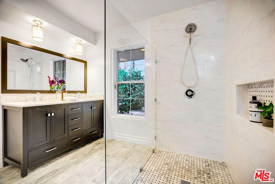 16561 Adlon Road Encino, CA 91436 - Photo 55 of 75 a spacious bathroom with a double vanity sink a mirror and shower