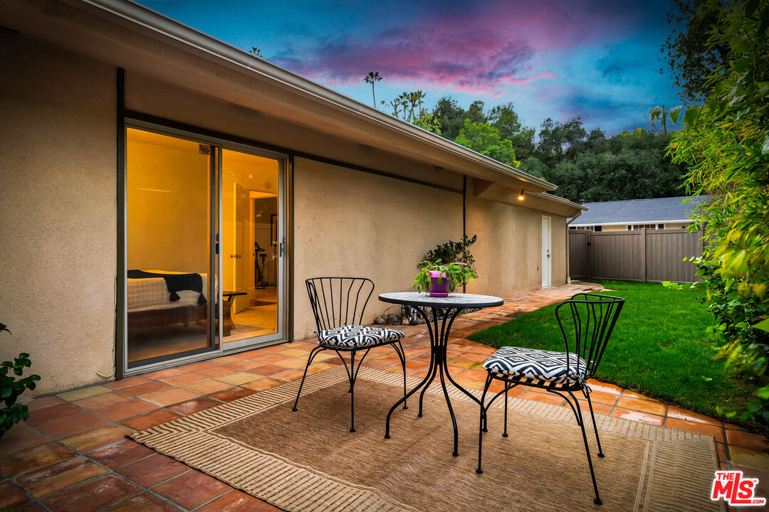 16561 Adlon Road Encino, CA 91436 - Photo 65 of 75 a porch with a table and chairs and potted plants