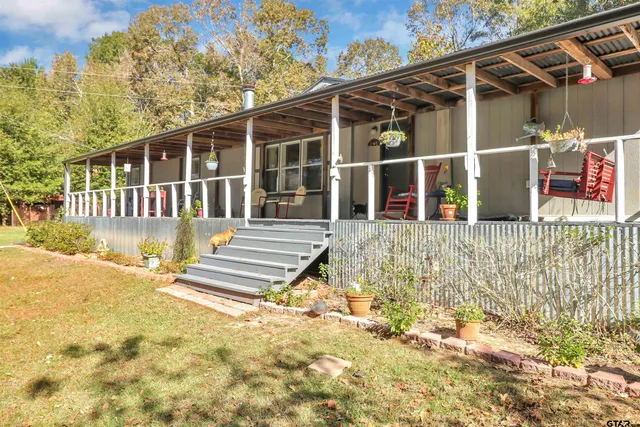 a view of a house with a large window and wooden fence