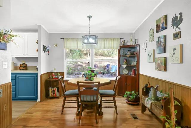 a dining room with furniture a chandelier and wooden floor