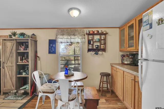 a kitchen with stainless steel appliances granite countertop a refrigerator and a dining table