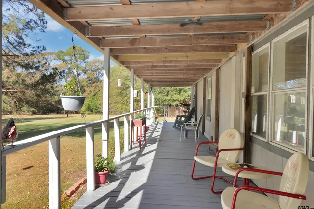 a view of a porch with furniture and wooden floor
