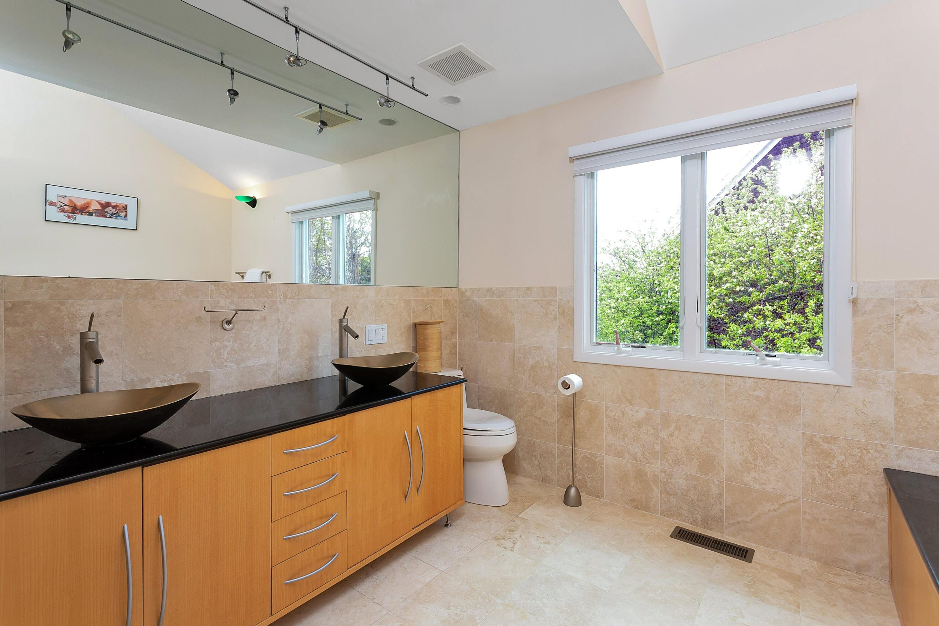 90 Roton Avenue Norwalk, CT 06853 - Photo 19 of 33 a spacious bathroom with a double vanity sink a large mirror and a toilet