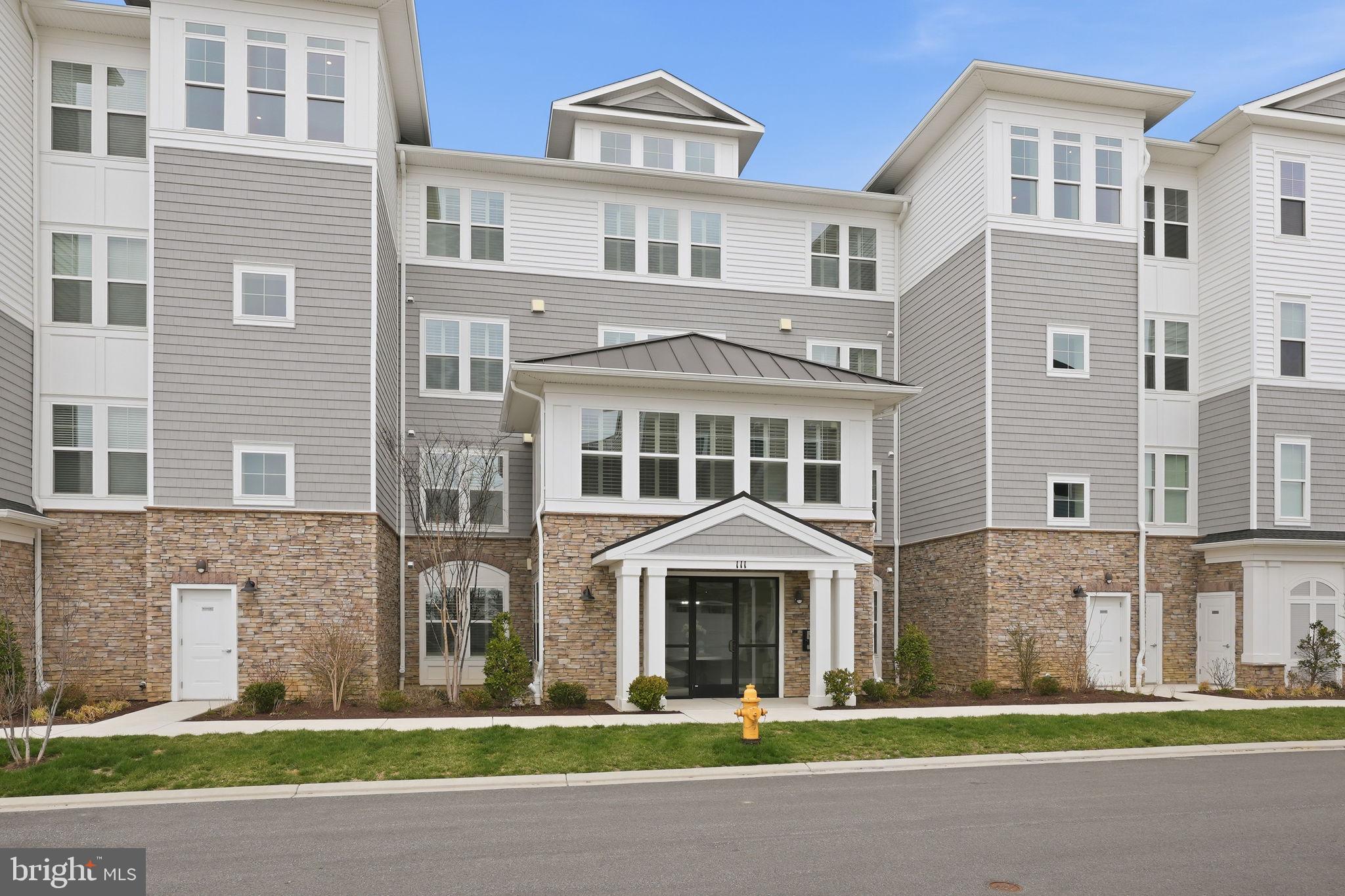 a front view of a residential apartment building with a yard