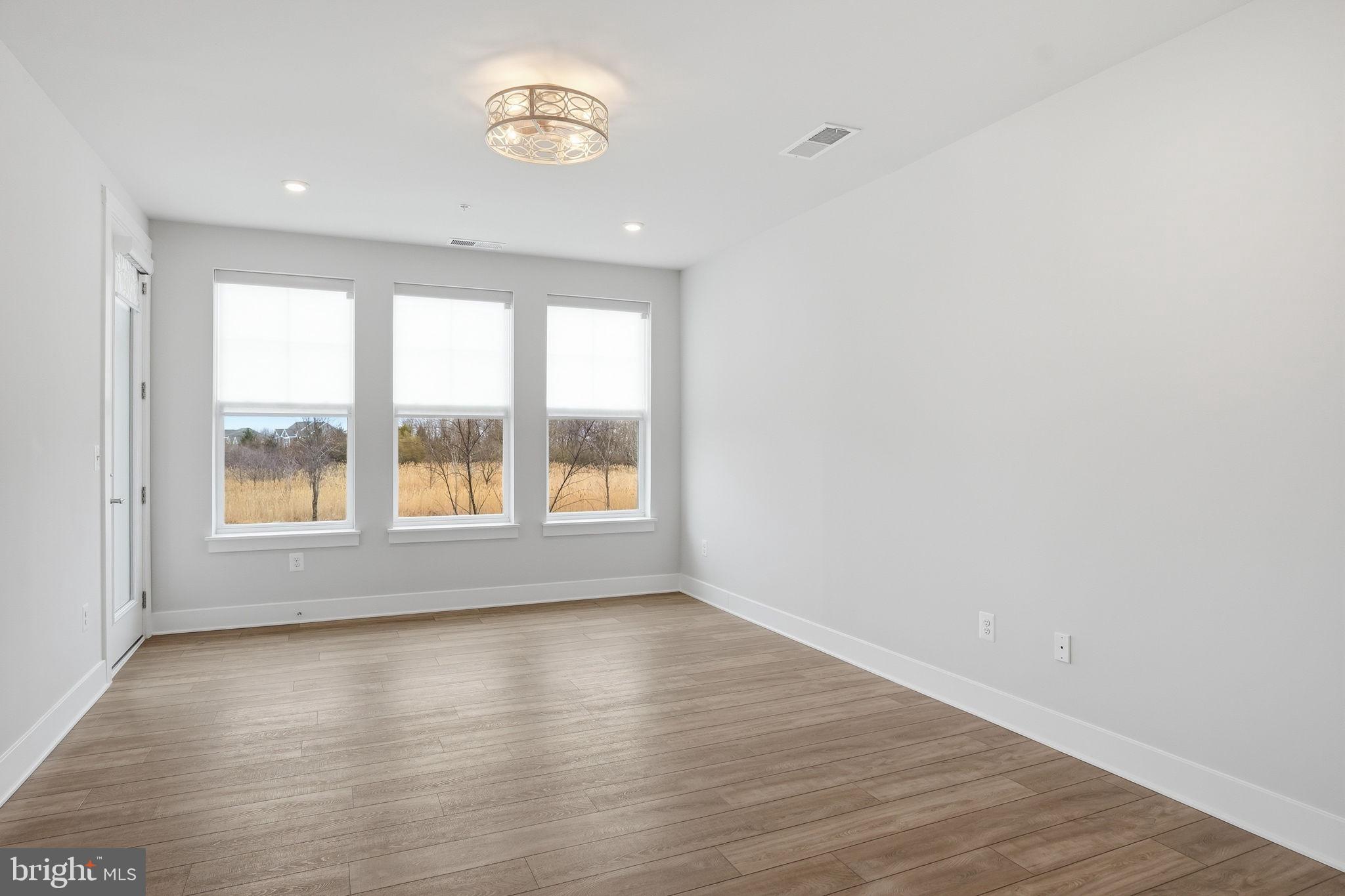111 Marshgrass Way, Unit 22 Chester, MD 21619 - Photo 16 of 102 wooden floor in an empty room with a window
