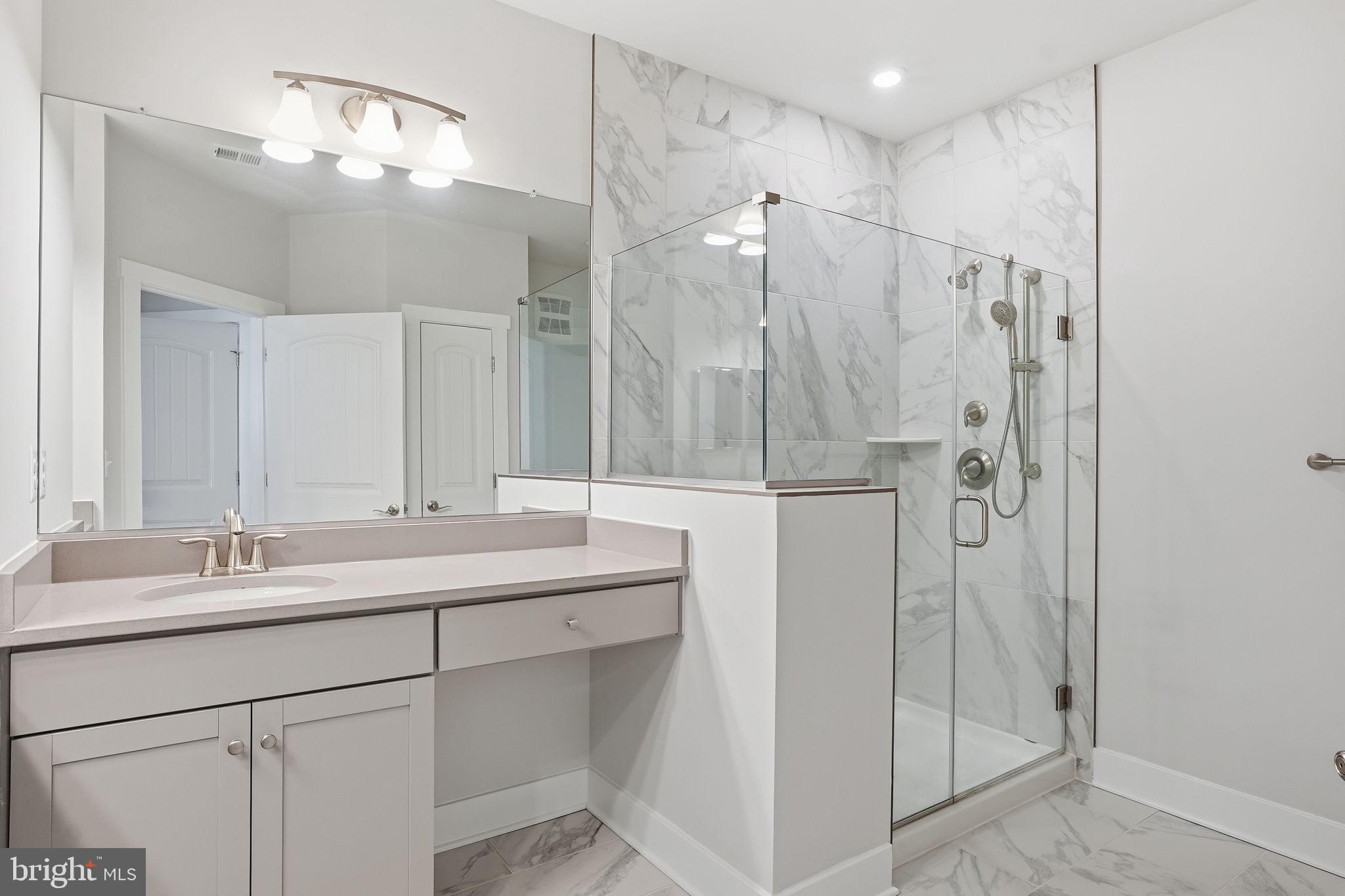 111 Marshgrass Way, Unit 22 Chester, MD 21619 - Photo 20 of 102 a bathroom with a double vanity sink mirror and shower
