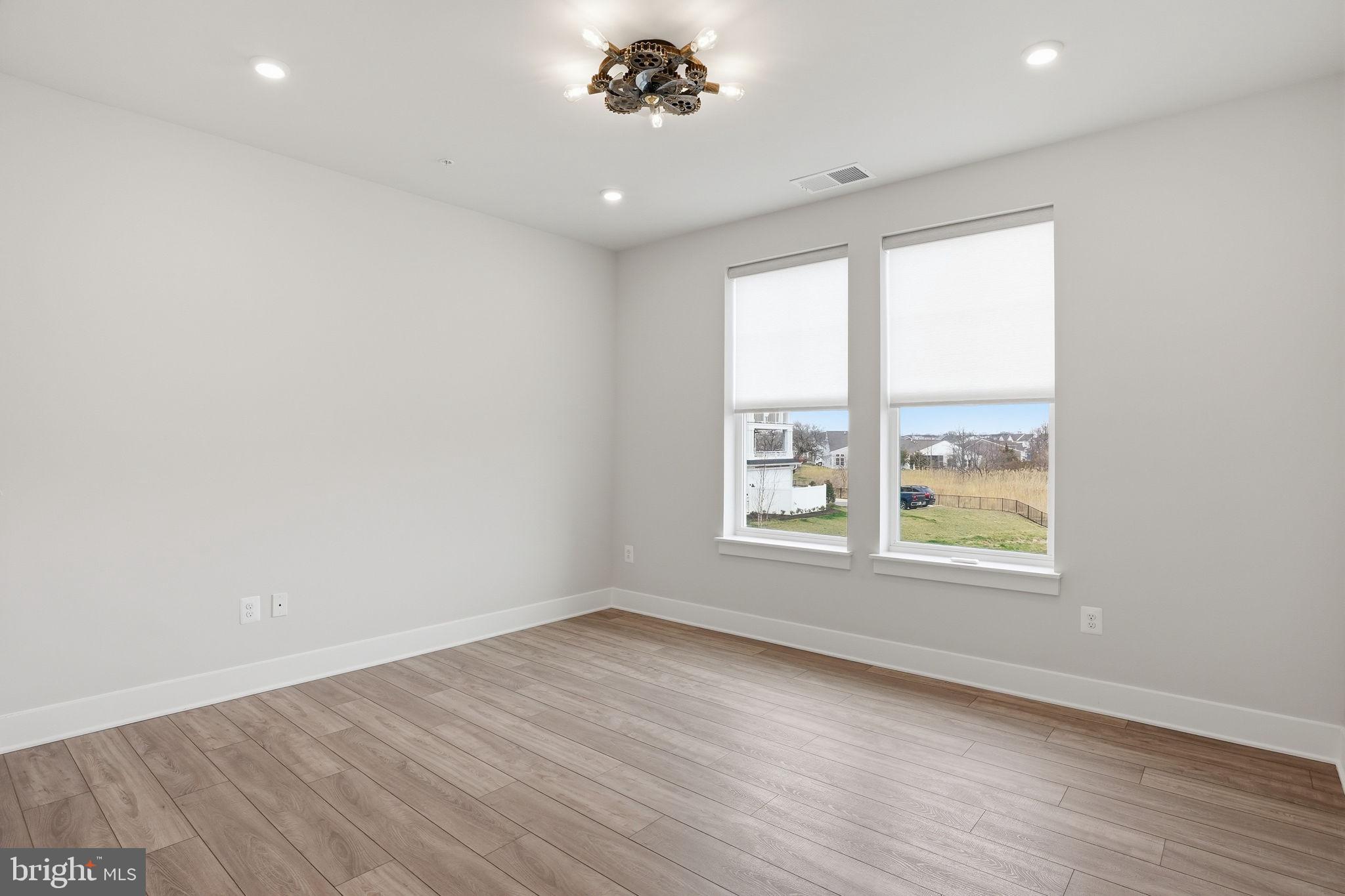 111 Marshgrass Way, Unit 22 Chester, MD 21619 - Photo 22 of 102 an empty room with wooden floor and windows